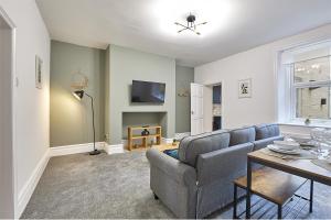 ein Wohnzimmer mit einem Sofa und einem Tisch in der Unterkunft Tyne View - Properties Unique in South Shields