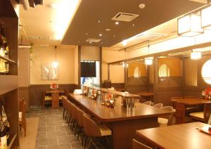 Hotel Route-Inn Yokohama Bashamichi في يوكوهاما: مطعم بطاولات وكراسي وبار