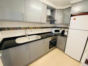 Kuchyň nebo kuchyňský kout v ubytování Apartamento en primera línea de playa con piscina y garaje gratuito