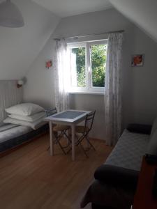 um pequeno quarto com uma mesa e uma janela em Przy morzu em Jarosławiec