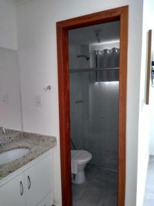 een badkamer met een toilet en een glazen douche bij MONTE CARMELLO Casa 01B in Porto Seguro