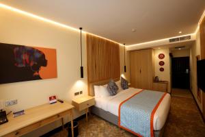Habitación de hotel con cama y escritorio en PrideInn Westlands Luxury Boutique Hotel, en Nairobi