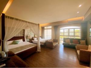 sypialnia z łóżkiem i kanapą w pokoju w obiekcie MorningSue Homestay w mieście Hualian