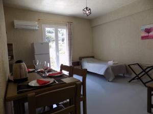 a room with a table and a room with a bed at Afrodite Spacious Apartments! in Ayia Evfimia