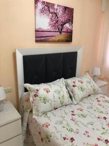 1 dormitorio con 1 cama con edredón rosa y blanco en APARTAMENTO A 50 METROS DE LA PLAYA DE SILGAR, en Sanxenxo