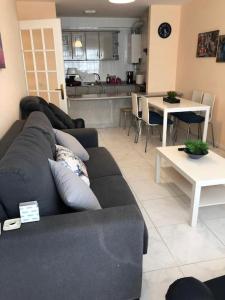 sala de estar con sofá, mesa y cocina en APARTAMENTO A 50 METROS DE LA PLAYA DE SILGAR, en Sanxenxo