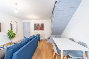 uma sala de estar com um sofá azul e uma mesa em St Pauls Square Holiday Home - Preston em Preston