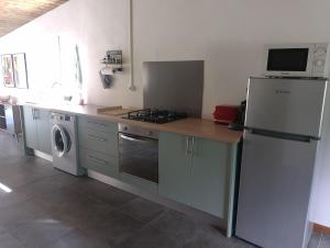 a kitchen with a refrigerator and a stove top oven at L'escale du Tec-Tec in Salazie