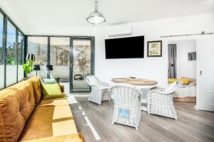 a living room with a couch and a table and chairs at Baltica Heaven by 2HomeRent - przestronne apartamenty premium przy samej plaży in Rogowo