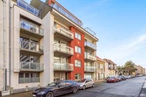 un edificio de apartamentos en una calle con coches aparcados en Luxury apartment with garden close to the beach en Ostende