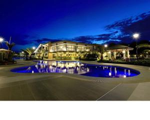 ダバオシティにあるVerdon Parc Condo 1 Bedroomの夜間にプールを目の前に設置した大きな建物