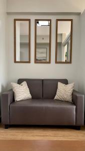 a couch in a living room with three mirrors at Verdon Parc Condo 1 Bedroom in Davao City