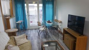 sala de estar con mesa y TV en Calido y comodo 2 amb y medio zona Torreon en Mar del Plata