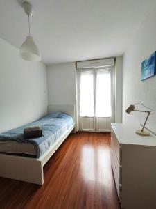 Schlafzimmer mit einem Bett, einem Schreibtisch und einem Fenster in der Unterkunft #Lesgourmandises in Mulhouse