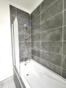 un bagno con vasca da bagno e doccia di #Lesgourmandises a Mulhouse