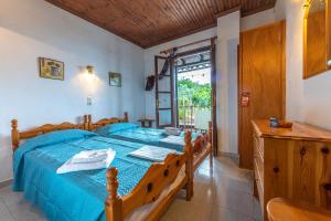 a bedroom with a bed with a blue comforter at SunRiseStudiosPapanero in Damouchari