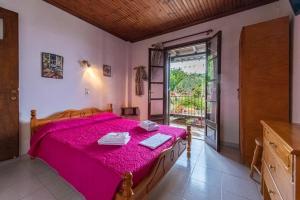 1 dormitorio con 1 cama con colcha rosa en SunRiseStudiosPapanero, en Damouchari