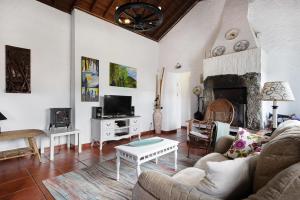 a living room with a couch and a fireplace at Paradise House Furnas in Furnas