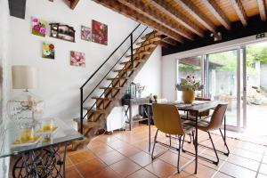 a dining room with a table and a staircase at Paradise House Furnas in Furnas