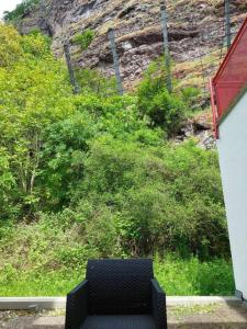 a chair sitting on a porch with a view of a hill at Ferienwohnung zentrale Lage in Idar-Oberstein