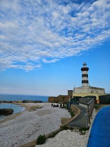 a lighthouse on a rocky beach next to the ocean at Casa Marina in Ortona