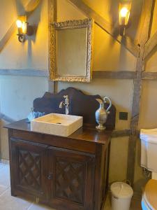 y baño con lavabo y espejo. en Le Château de Cambiaire en Saint-Étienne-Vallée-Française
