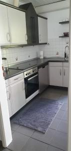 a kitchen with white cabinets and a sink and an oven at Ferienwohnung zentrale Lage in Idar-Oberstein