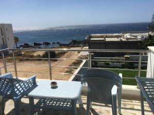 a table and chairs on a balcony with a view of the ocean at Arabesque Style - 2 appartements in Kelibia