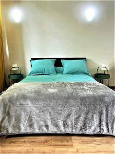 1 cama grande con almohadas azules y 2 mesas en BLUE FOUNTAIN Luxueux Studio Aix Centre Historique -WIFI-SMART TV- en Aix-en-Provence