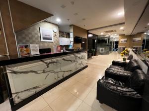 a lobby with a marble counter and leather chairs at Signature Hotel in Kuantan