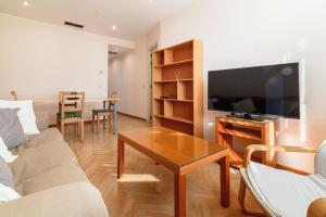 a living room with a couch and a tv and a table at Cozy Apartment Chamberi VII Renovated 1BR 1BH in Madrid