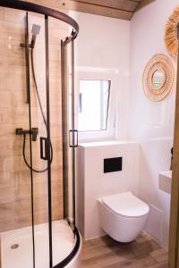 a white bathroom with a shower and a toilet at La Playa Resort & Camp Trzebinia in Trzebinia