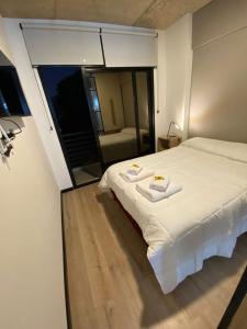 Un dormitorio con una cama blanca y una mesa. en Depto. PREMIUIM - Edificio USINA en Salta
