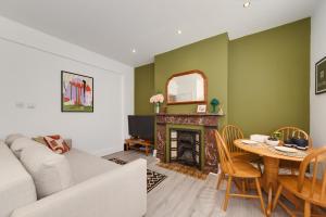 a living room with a couch and a table with a fireplace at Number7, 3 minutes to the Beach, Super King Beds, Part of Burlington-Escapes in Brighton & Hove