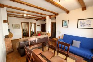 a living room with a blue couch and a table at casa del gastronomo in Cortes de la Frontera