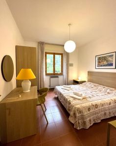 1 dormitorio con cama, escritorio y lámpara en Appartamenti Portiglioni-Belvedere, en Puntone di Scarlino