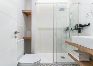 a bathroom with a shower and a toilet and a sink at Limehome Madrid Calle de Luchana - estancia temporal in Madrid