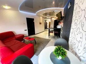 a living room with a red couch and a table at Apartment-Hotel Panorama in Dnipro