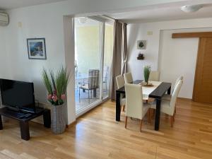 a dining room with a table and chairs and a television at Apartment David in Biograd na Moru