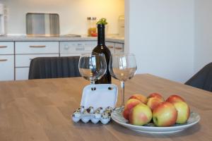 - une table avec une assiette de pommes et une bouteille de vin dans l'établissement Appartement 7, à Caldaro 4 autres photos