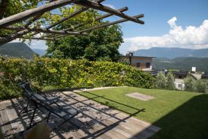 un jardin avec un banc, de l'herbe et des montagnes dans l'établissement Appartement 7, à Caldaro