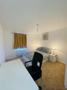 ein Schlafzimmer mit einem Bett und einem Stuhl in einem Zimmer in der Unterkunft Anox serviced Apartments 2 in Newcastle upon Tyne