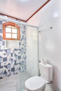 a bathroom with a toilet and a glass shower at Casa Carvalho in Paraty