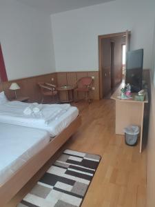 um quarto de hotel com uma cama e uma televisão em Park Hotel em Nagyatád