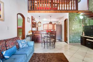 a living room with a blue couch and a kitchen at Casa Carvalho in Paraty