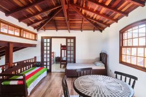 a room with two beds and a table and chairs at Casa Carvalho in Paraty +47 photos