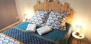 a bedroom with a bed with two towels and two lamps at Maison chaleureuse avec insert en campagne in Saint-Mars-sur-la-Futaie