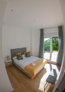 um quarto com uma cama e uma grande janela em Costaserenasuites em Nigrán