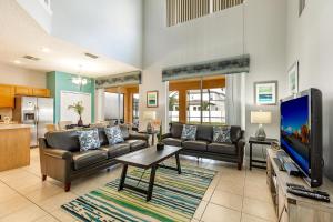 a living room with couches and a flat screen tv at Tiger Lilly at Ellis Exclusive Villas in Kissimmee