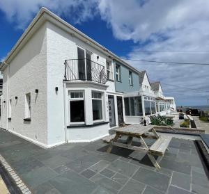 a white house with a picnic table in front of it at HipNautic, Mevagissey, Sleeps 6 in Mevagissey